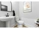 Stylish half-bath features a sleek pedestal sink, modern toilet, and attractive mirror at 501 Rhythm St, Summerville, SC 29486