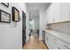 Elegant hallway with white walls, wood floors, and a convenient bar area featuring modern white cabinetry at 501 Rhythm St, Summerville, SC 29486