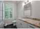 Bathroom featuring granite counters, stylish vanity, and a window with plantation shutters at 5152 Coral Reef Dr, Johns Island, SC 29455