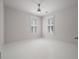 Bright bedroom featuring crisp white trim, light grey paint, shuttered windows, and a modern ceiling fan at 5152 Coral Reef Dr, Johns Island, SC 29455