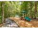 Outdoor playground with play structure and swings surrounded by mature trees at 5152 Coral Reef Dr, Johns Island, SC 29455