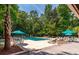 Outdoor pool area with lounge chairs and umbrella tables surrounded by lush greenery at 5152 Coral Reef Dr, Johns Island, SC 29455