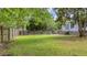 A spacious backyard featuring lush grass, bordered by a wooden fence and mature trees at 600 Dolphin Dr, Summerville, SC 29485