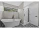Bathroom with claw foot tub, glass shower, patterned floor tile, and a large window at 600 Dolphin Dr, Summerville, SC 29485