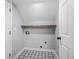 Empty laundry room with unique tile floor, a wooden shelf, and washer/dryer hookups at 600 Dolphin Dr, Summerville, SC 29485