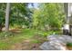 Large, grassy backyard with mature trees and a concrete patio area at 633 Alwyn Blvd, Summerville, SC 29485