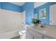 Bright blue bathroom features a tub and shower combo plus a modern white vanity at 633 Alwyn Blvd, Summerville, SC 29485