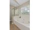 Elegant bathroom featuring a soaking tub with jets, a window with blinds, and a glass shower at 633 Alwyn Blvd, Summerville, SC 29485