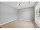 Empty bedroom showcasing neutral paint, tile floors, and a window with natural light at 633 Alwyn Blvd, Summerville, SC 29485