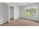 Cozy bedroom with plush carpeting, large window overlooking neighborhood, and closet with bi-fold doors at 633 Alwyn Blvd, Summerville, SC 29485