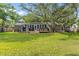 Backyard with deck, seating, large trees, lush green grass, and shade at 689 Port Cir, Charleston, SC 29412