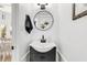 Modern bathroom featuring a black vanity, round mirror, and white subway tile at 689 Port Cir, Charleston, SC 29412