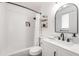 Bathroom with a tiled tub, a black vanity, and a round mirror at 689 Port Cir, Charleston, SC 29412