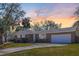 Charming brick home with manicured lawn and beautiful trees under a colorful sky at 689 Port Cir, Charleston, SC 29412