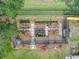 Aerial view of a fenced vegetable garden with raised beds, stone pathways, and abundant sunshine at 689 Port Cir, Charleston, SC 29412