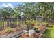 Landscaped backyard featuring raised garden beds, gravel, and stone pathways amidst mature trees at 689 Port Cir, Charleston, SC 29412
