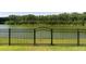 Wrought iron fence surrounding the backyard with mature trees and access to the lake at 7011 Pumpkinseed Dr, Johns Island, SC 29455