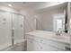 Bright bathroom with glass shower and white vanity with a large mirror at 7011 Pumpkinseed Dr, Johns Island, SC 29455