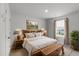 Relaxing bedroom with a large bed, stylish lamps, window and a rustic wooden chest at the foot of the bed at 7011 Pumpkinseed Dr, Johns Island, SC 29455
