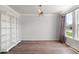 Bright, empty room with white trim, hardwood floors, custom light fixture, and natural light from the window at 7011 Pumpkinseed Dr, Johns Island, SC 29455