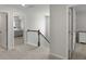 Upstairs hallway featuring a staircase with wooden banister and natural light in neutral tones at 7011 Pumpkinseed Dr, Johns Island, SC 29455