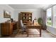 Inviting home office with built in shelves, wood desk, neutral walls, and natural light from large windows at 7011 Pumpkinseed Dr, Johns Island, SC 29455