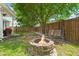 Backyard view of a cozy firepit area with an outdoor swing and mature tree at 7030 Billberry St, Hanahan, SC 29410