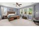 A primary bedroom features a wooden bed frame, ceiling fan, and natural light at 7030 Billberry St, Hanahan, SC 29410