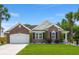 Beautiful brick home with a well-manicured lawn, tall palm trees and an attached garage at 7030 Billberry St, Hanahan, SC 29410