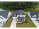Aerial view of home with large lawn, driveway, and view of pond in the backyard at 7035 Pumpkinseed Dr, Johns Island, SC 29455