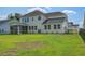 The back exterior of a two-story house features a covered porch and a large yard at 7035 Pumpkinseed Dr, Johns Island, SC 29455