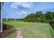 Wide backyard with wrought iron fence overlooking a pond and mature trees at 7035 Pumpkinseed Dr, Johns Island, SC 29455