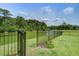 Scenic back yard featuring a tranquil pond bordered by a wrought iron fence at 7035 Pumpkinseed Dr, Johns Island, SC 29455