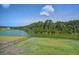 Wide backyard with wrought iron fence overlooking a pond and mature trees at 7035 Pumpkinseed Dr, Johns Island, SC 29455