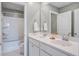 Bright bathroom featuring double sinks, a large mirror, white cabinets, and a shower-tub combo at 7035 Pumpkinseed Dr, Johns Island, SC 29455