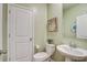 A compact bathroom with a pedestal sink, framed mirror, and white fixtures provides essential functionality at 7035 Pumpkinseed Dr, Johns Island, SC 29455
