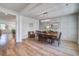 Chic dining room features a modern chandelier, wainscotting, and wood floors at 7035 Pumpkinseed Dr, Johns Island, SC 29455