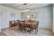 Chic dining room features a modern chandelier, wainscotting, and wood floors at 7035 Pumpkinseed Dr, Johns Island, SC 29455