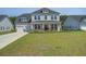 Charming two-story home boasts a two-car garage, large front yard and inviting front porch at 7035 Pumpkinseed Dr, Johns Island, SC 29455
