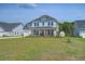 Charming two-story home boasts a two-car garage, large front yard and inviting front porch at 7035 Pumpkinseed Dr, Johns Island, SC 29455