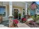 Inviting front porch featuring a swing, seating, potted plants, and American flag at 7035 Pumpkinseed Dr, Johns Island, SC 29455