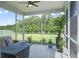 Relaxing screened porch overlooking the backyard with views of a pond and green trees at 7035 Pumpkinseed Dr, Johns Island, SC 29455