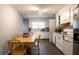 Functional kitchen with white cabinets, a window, and appliances, with a dining table for meals at 7621 Oldridge Rd, North Charleston, SC 29418