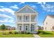 Charming two-story home with blue siding, white trim, a front porch, and a well-manicured lawn at 770 Clay Field Trl, Summerville, SC 29485