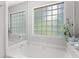 Bright bathroom features a soaking tub with tiled glass block windows and neutral wall paint at 800 Heyward Cove Pl, Charleston, SC 29412
