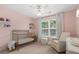 Bedroom features a gold crib, a glider and natural lighting from a large window at 800 Heyward Cove Pl, Charleston, SC 29412