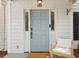Inviting front door with decorative sidelights and charming chair, showcasing welcoming entrance at 800 Heyward Cove Pl, Charleston, SC 29412
