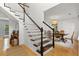 Elegant staircase leads to dining area with stylish light fixture and hardwood floors at 800 Heyward Cove Pl, Charleston, SC 29412