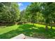 Large backyard with an expansive lawn, bordered by a wooden fence and mature trees at 8112 Halifax Way, North Charleston, SC 29420