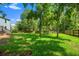 A luscious green yard backs up to trees with a wooden fence with the house to the left at 8112 Halifax Way, North Charleston, SC 29420